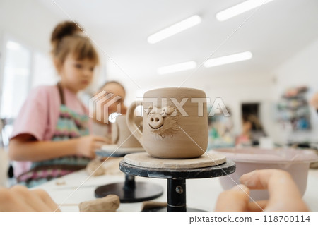 Children enjoying a pottery class while creating unique mugs in a studio Children enjoying a pottery class while creating unique mugs in a studio 118700114