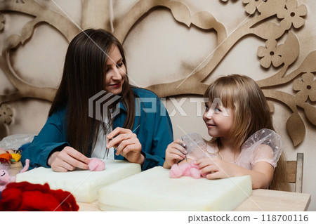A mother and daughter enjoy crafting together in a bright room A mother and daughter enjoy crafting together in a bright room 118700116