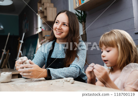 Creating art together at a pottery class with a child in a cozy studio Creating art together at a pottery class with a child in a cozy studio 118700119