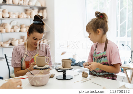 Artistic pottery session with child at a creative studio in the afternoon Artistic pottery session with child at a creative studio in the afternoon 118700122