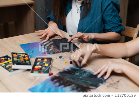 Creative individuals engaged in pastel art at a wooden table Creative individuals engaged in pastel art at a wooden table 118700159