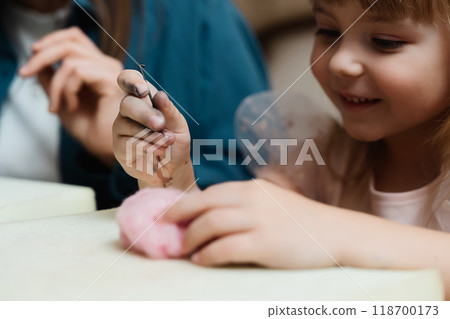 girl enjoys crafting with pink clay in a cozy indoor setting girl enjoys crafting with pink clay in a cozy indoor setting 118700173