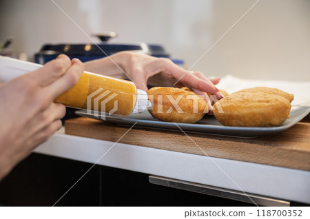 Filling homemade fried vegan doughnuts with apricot jam Filling homemade fried vegan doughnuts with apricot jam 118700352
