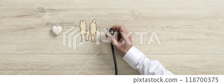 Doctor holding medical stethoscope over a cut out of a family 118700375