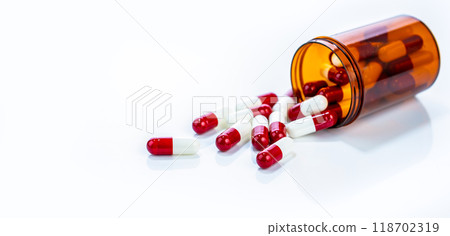 Safety regulated prescription drugs. Capsules pill tumbling from plastic container. Stringent pharmaceutical industry standards and ongoing efforts to ensure medication efficacy and patient well being Safety regulated prescription drugs. Capsules pill tumbling from plastic container. Stringent pharmaceutical industry standards and ongoing efforts to ensure medication efficacy and patient well being 118702319