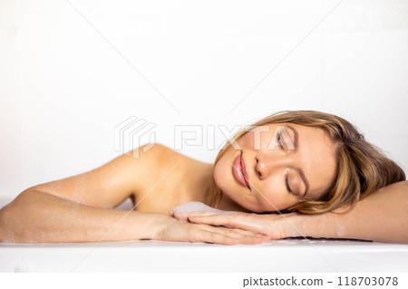 A young, beautiful, smiling, sexy and happy woman with long hair takes a bath with foam 118703078