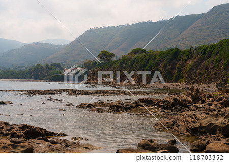Coastal View of Rocky Shoreline with Hills and Seaside House Coastal View of Rocky Shoreline with Hills and Seaside House 118703352