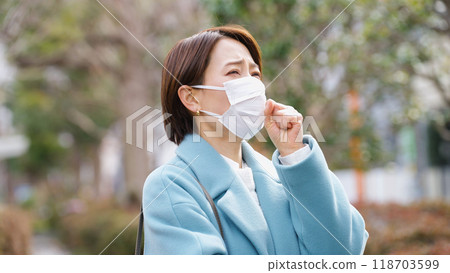 A woman coughing while wearing a mask (winter clothes, jacket, coat) 118703599