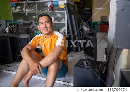Asian male technician sitting on the floor during a break from work 118704674