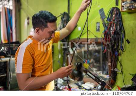 Repairman selects cables to connect during work in the electronics repair room 118704707