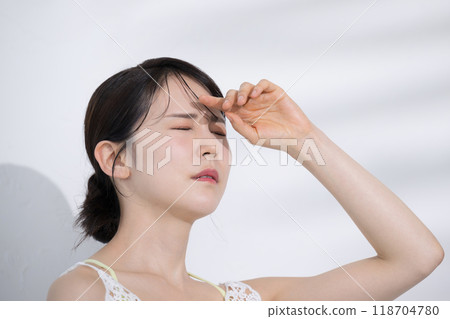Summer beauty image: Young woman worried about the sun's ultraviolet rays, summer whitening and whitening without tanning, eyes closed, troubled face Summer beauty image: Young woman worried about the sun's ultraviolet rays, summer whitening and whitening without tanning, eyes closed, troubled face 118704780