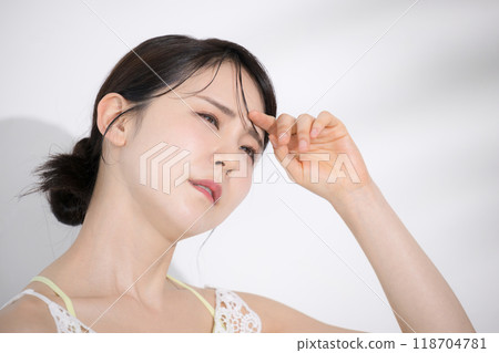 Summer beauty image: Young woman worried about the sun's ultraviolet rays, summer whitening and whitening without tanning, dazzling and troubled face Summer beauty image: Young woman worried about the sun's ultraviolet rays, summer whitening and whitening without tanning, dazzling and troubled face 118704781