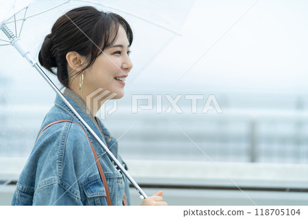A woman going out in the rain A woman traveling during the rainy season 118705104
