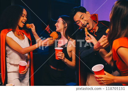 Joyful office Halloween party with coworkers in costumes, celebrating with drinks and laughter, fostering teamwork and festive spirit 118705131