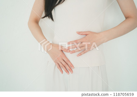 Woman rubbing her abdomen with her hand Woman rubbing her abdomen with her hand 118705659