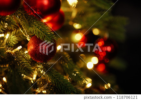 Close-up of a Christmas tree with red balls and bokeh in the background. 118706121