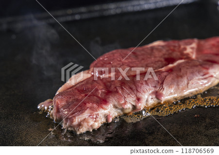 Grilling beef steak on an iron plate 118706569