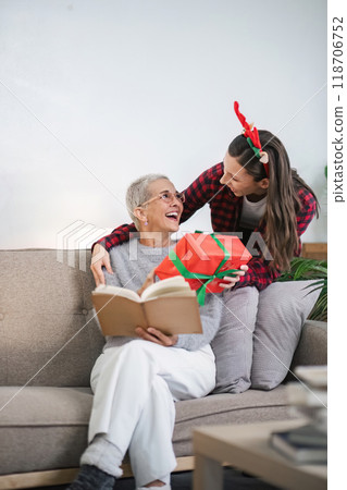 Christmas Morning Delight Young Woman Surprises Grandmother with a Heartfelt Gift 118706752