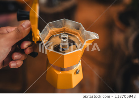 Hand holding coffee from a moka pot 118706948