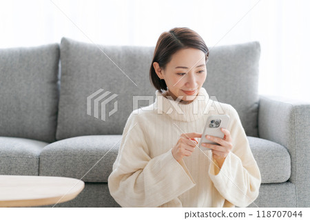 Woman operating a smartphone Woman operating a smartphone 118707044