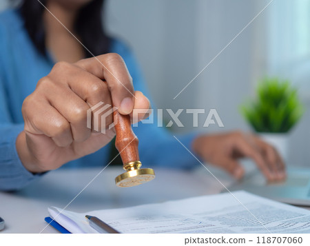 Businesswoman hand stamping with approved stamp on text approved document at desk, Validates and manages business documents and agreements, Approval stamp, Signing on business partner paper to success Businesswoman hand stamping with approved stamp on text approved document at desk, Validates and manages business documents and agreements, Approval stamp, Signing on business partner paper to success 118707060