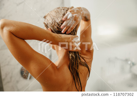 A Woman Enjoying a Showering Experience Hair Care Routine in a Modern Bathroom Setting A Woman Enjoying a Showering Experience Hair Care Routine in a Modern Bathroom Setting 118707302