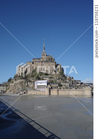 Mont Saint-Michel and the tidal flats against the blue sky 118708231
