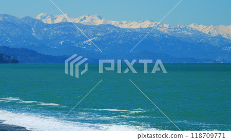 Waves Rolling On Sea A Windy Day. Blue Sky And Snow-Capped Mountains. Still. 118709771