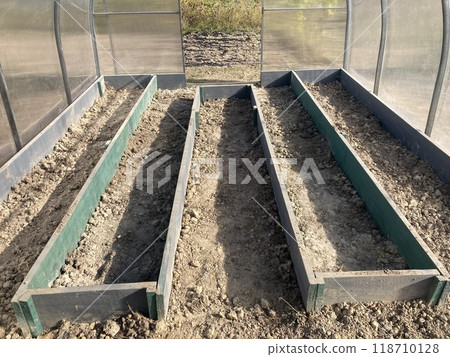 Installing wooden beds in a greenhouse 118710128