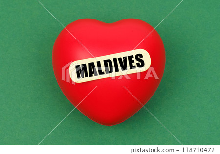 On a green surface lies a red heart with the inscription - Maldives 118710472