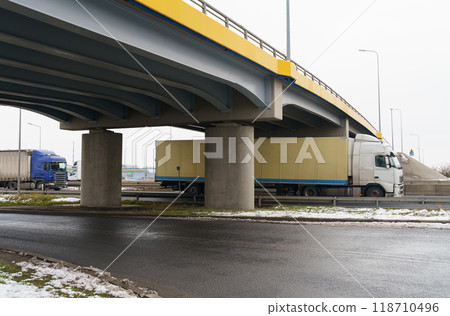 Trucks drive under the transport bridge. Transport logistics Trucks drive under the transport bridge. Transport logistics 118710496