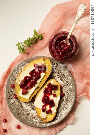 Bread with butter and lingonberry jam on pink cheesecloth Bread with butter and lingonberry jam on pink cheesecloth 118710894