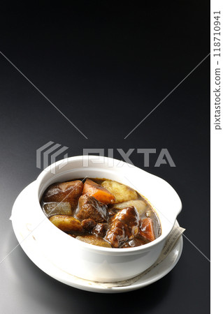 Beef stew with chunky vegetables photographed against a black background Beef stew with chunky vegetables photographed against a black background 118710941