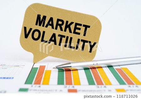 On the financial charts lies a pen and a sign with the inscription - Market Volatility On the financial charts lies a pen and a sign with the inscription - Market Volatility 118711026