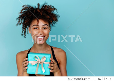 Happy birthday girl with a gift in her hands on a blue background Happy birthday girl with a gift in her hands on a blue background 118711697
