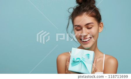 Happy birthday girl with a gift in her hands on a blue background Happy birthday girl with a gift in her hands on a blue background 118711699