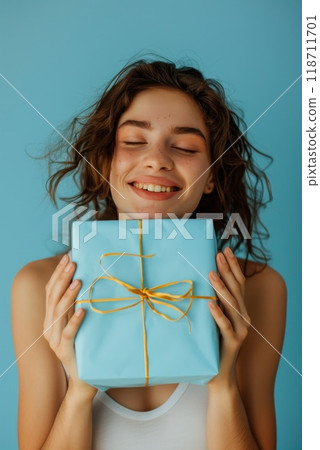 Happy birthday girl with a gift in her hands on a blue background 118711701
