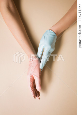 Multicolored blue and pink gloves on female hands Multicolored blue and pink gloves on female hands 118711862