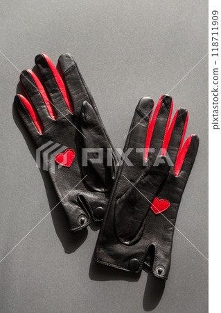 A pair of leather gloves with a red heart on the palm and red inserts on the fingers 118711909