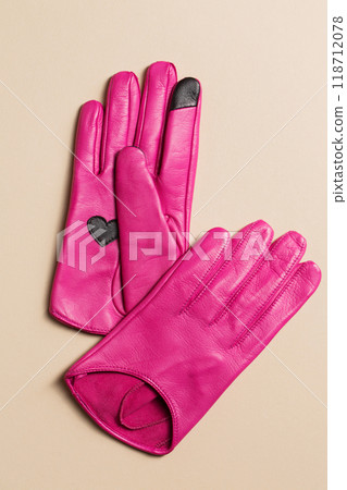 A pair of bright pink leather gloves with a heart 118712078