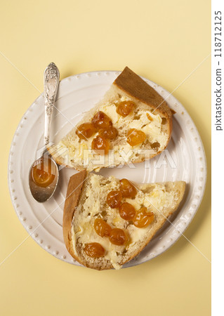 Homemade bread, butter and yellow cherry jam on a white plate Homemade bread, butter and yellow cherry jam on a white plate 118712125