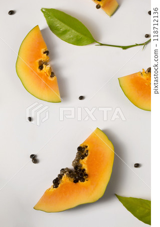 Fruit background made of pieces of papaya on a white background Fruit background made of pieces of papaya on a white background 118712136