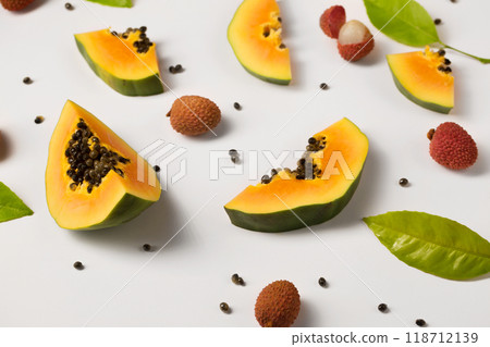 Fruit background made of pieces of ripe papaya and litchi on a white background Fruit background made of pieces of ripe papaya and litchi on a white background 118712139