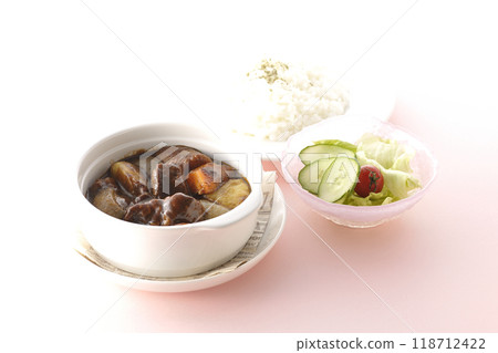 A set of beef stew with chunks of meat and vegetables, rice and salad A set of beef stew with chunks of meat and vegetables, rice and salad 118712422