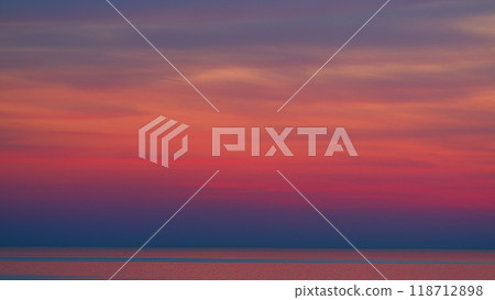 Fiery Purple Or Pink And Violet Colors Sunsets Over Ocean. Bright Sunset With Sun Over Calm Sea Surface. 118712898