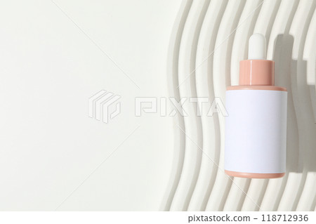 Cosmetic oil in a bottle on a light background 118712936
