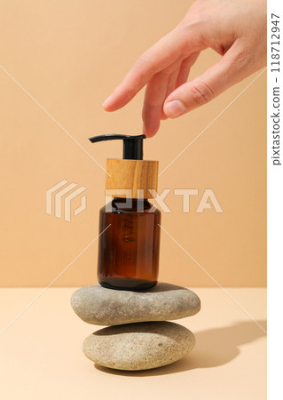 Cosmetic oil in a brown bottle with pebbles 118712947