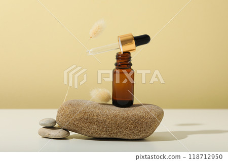 Cosmetic oil in a brown bottle with a pebble Cosmetic oil in a brown bottle with a pebble 118712950