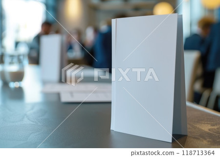 A white sheet of paper stands on a desk in the office. A blank sheet of paper on a table in the room A white sheet of paper stands on a desk in the office. A blank sheet of paper on a table in the room 118713364