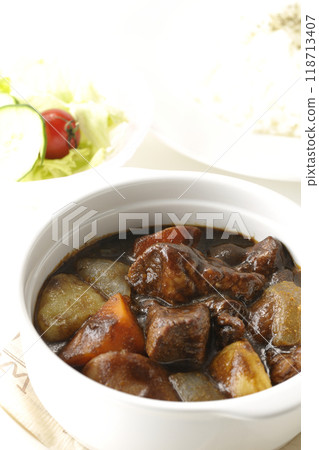 A set of beef stew with chunks of meat and vegetables, rice and salad A set of beef stew with chunks of meat and vegetables, rice and salad 118713407